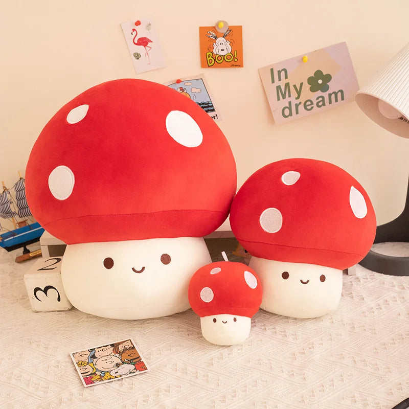 A set of adorable mushroom plush pillows in red and white, displayed against a light wall.