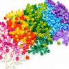 A colorful assortment of small, round building blocks in various shades of green, yellow, orange, pink, and purple.