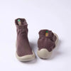 A pair of brown knit baby first walker socks with a pineapple detail and soft soles.