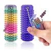 A hand holds a purple spiky fidget key charm for stress relief, showing its texture and 360-degree view.