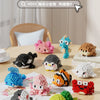 A collection of colorful penguin and sea animal 3D construction figures made from clay on a wooden table.