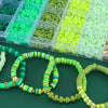 A collection of colorful clay and alphabet beads for DIY jewelry making displayed in clear plastic compartments.