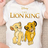 A baby wearing a white bodysuit featuring a Disney The Lion King print of Simba and Mufasa.