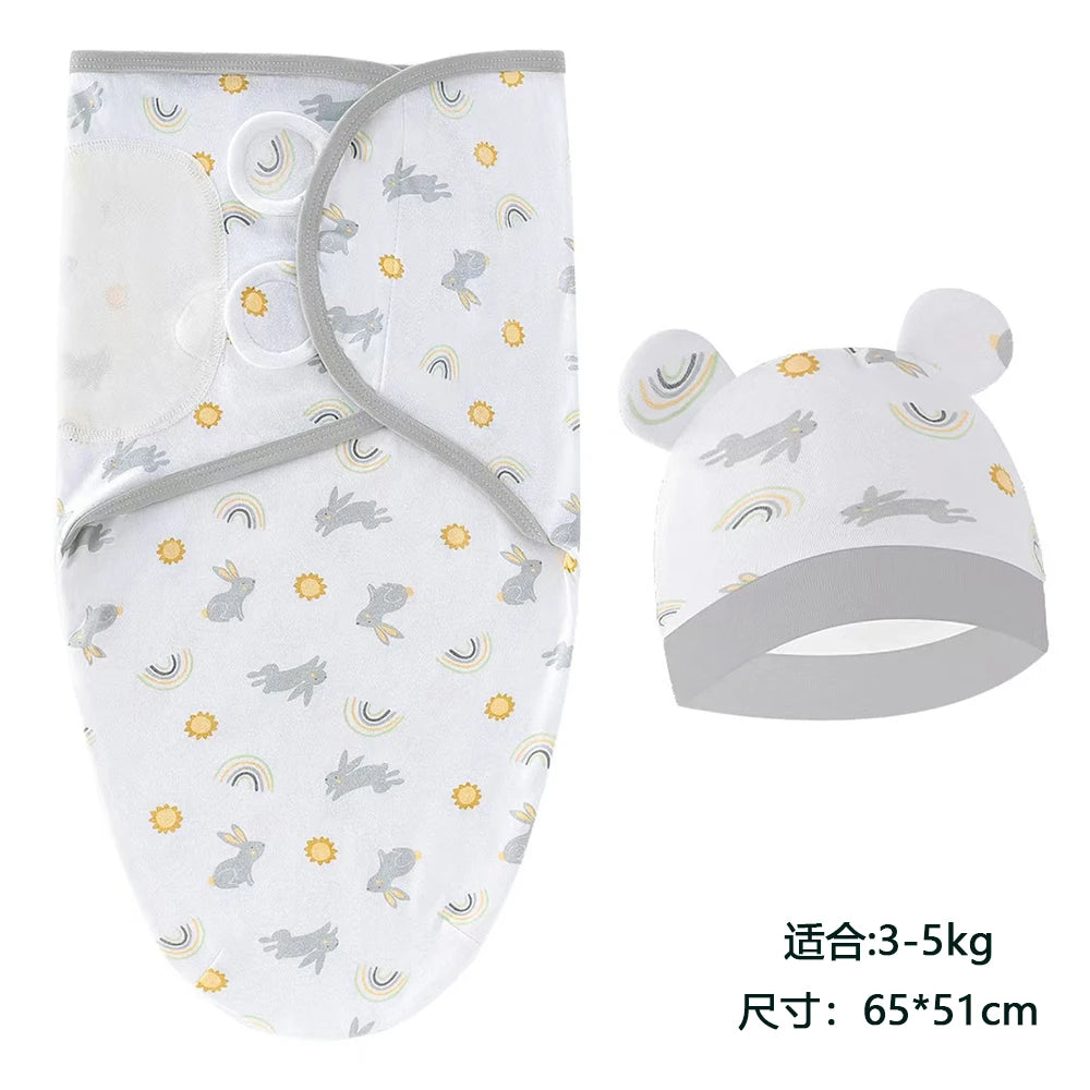 A white cotton newborn swaddle blanket and hat set featuring a pattern of gray rabbits and yellow rainbows.