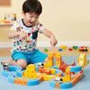 A child is playing with a yellow and orange magnetic 3D cube train set featuring flexible tracks on a blue surface.