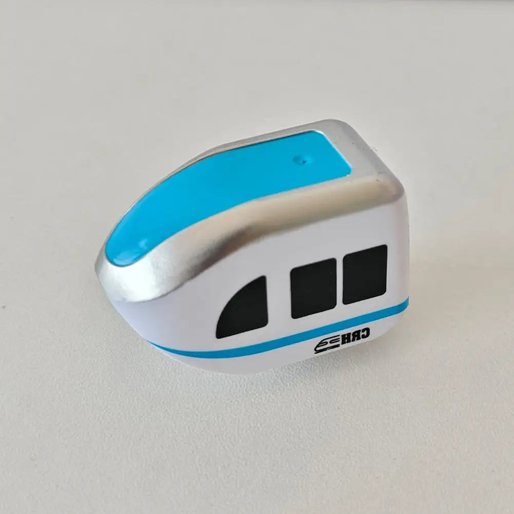 A silver and light blue anti-gravity magnetic mini train with black windows resting on a white surface.