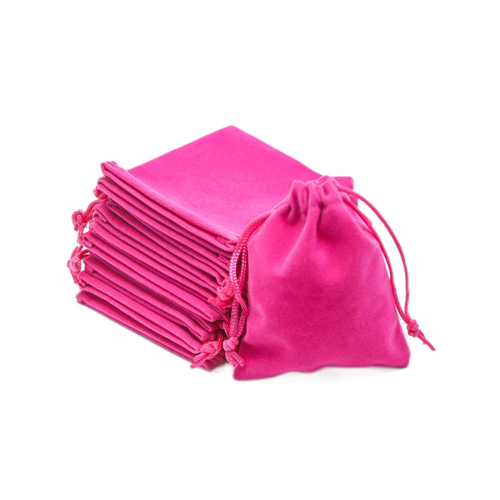 A stack of bright pink compact drawstring dice bags for tabletop games.