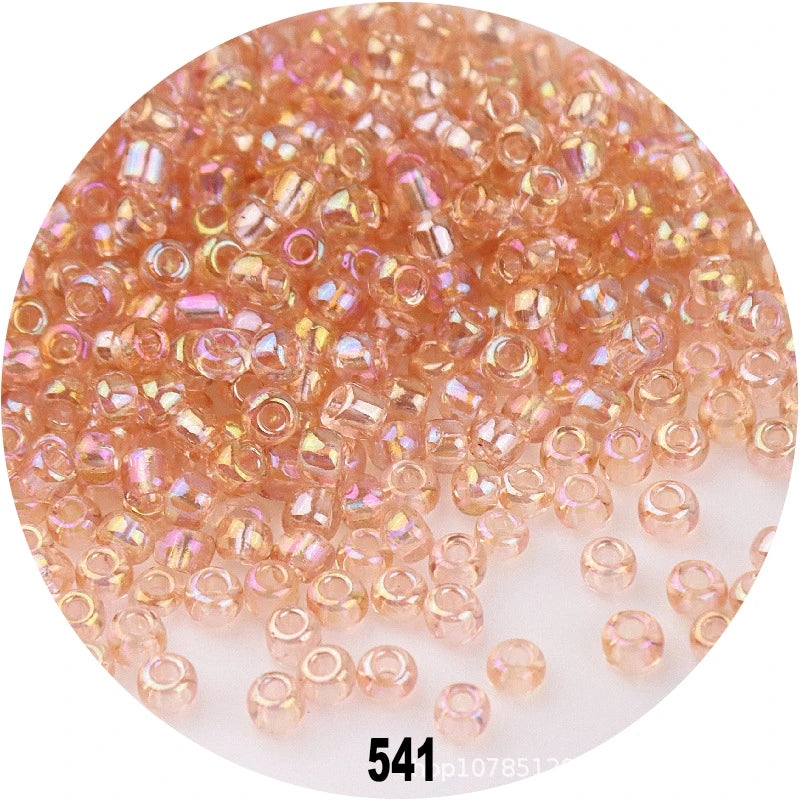 A close-up view of loose, colorful round glass seed beads for jewelry making.