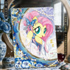 A collectible card featuring a pink pony character with blue accents and a sparkling background.