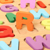 A close-up view of colorful wooden alphabet puzzle pieces scattered on a light wooden surface.