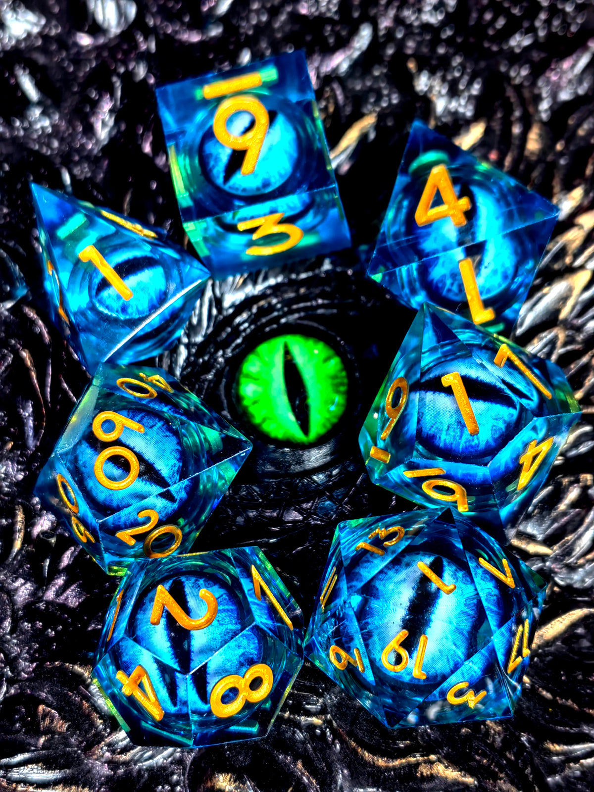 A set of blue resin dice with numbers and a spinning dragon eye core for role-playing games