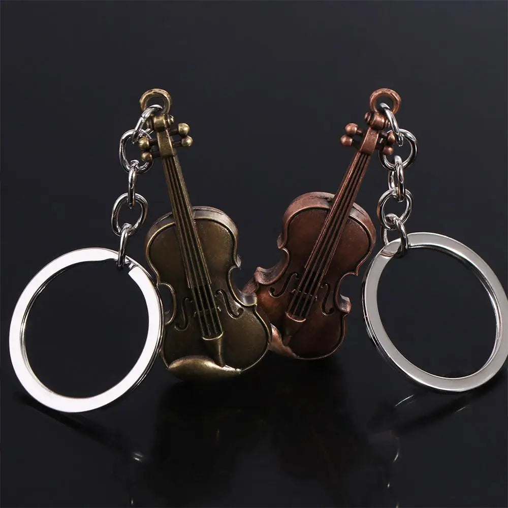 A vintage violin keychain featuring brass and wood tones, attached to a silver ring.