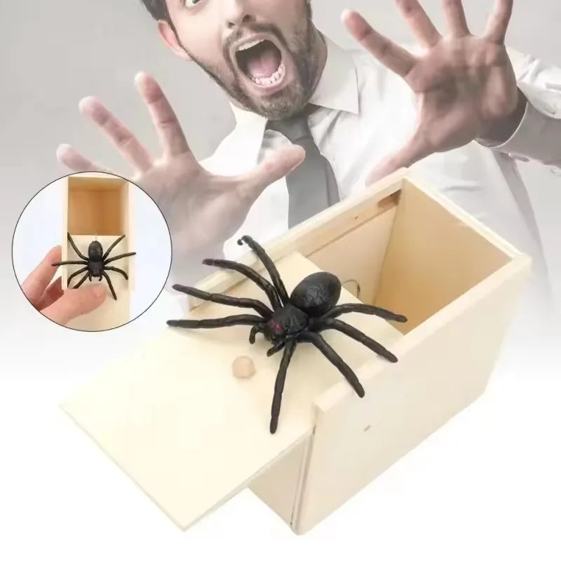 Une boîte en bois contenant une araignée noire à côté d'une main présentant une araignée pour une farce.