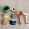 A set of kids sand and water play items including a green bucket, an orange bulldozer, and various plastic toys.