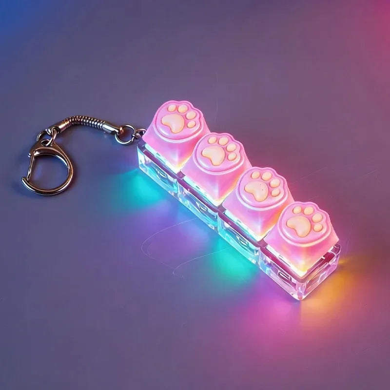 A clear acrylic keychain fidget toy shaped like paw prints with pink LED lights