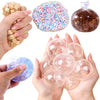 Hands display a set of six clear soft squeeze balls, including colorful and brown varieties, for stress relief.