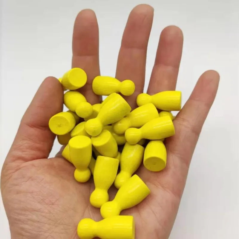 A hand holds a set of ten yellow wooden chess pawns for board games.