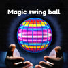 A glowing, colorful magic swing ball is held between two hands against a dark background.