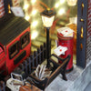 A miniature diorama featuring a red mailbox, a lantern, and wooden structures.