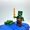 A Minecraft Steve PVC figure set featuring a green character holding an orange staff on a blue base.