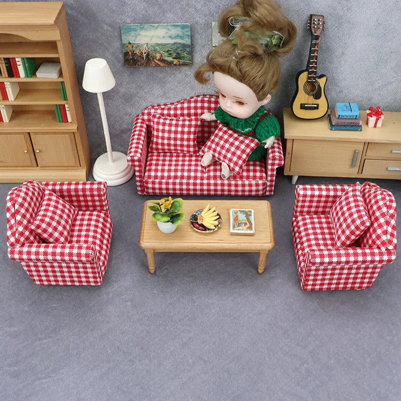 A miniature doll sofa set with a red and white checkered fabric, a doll, and wooden furniture.