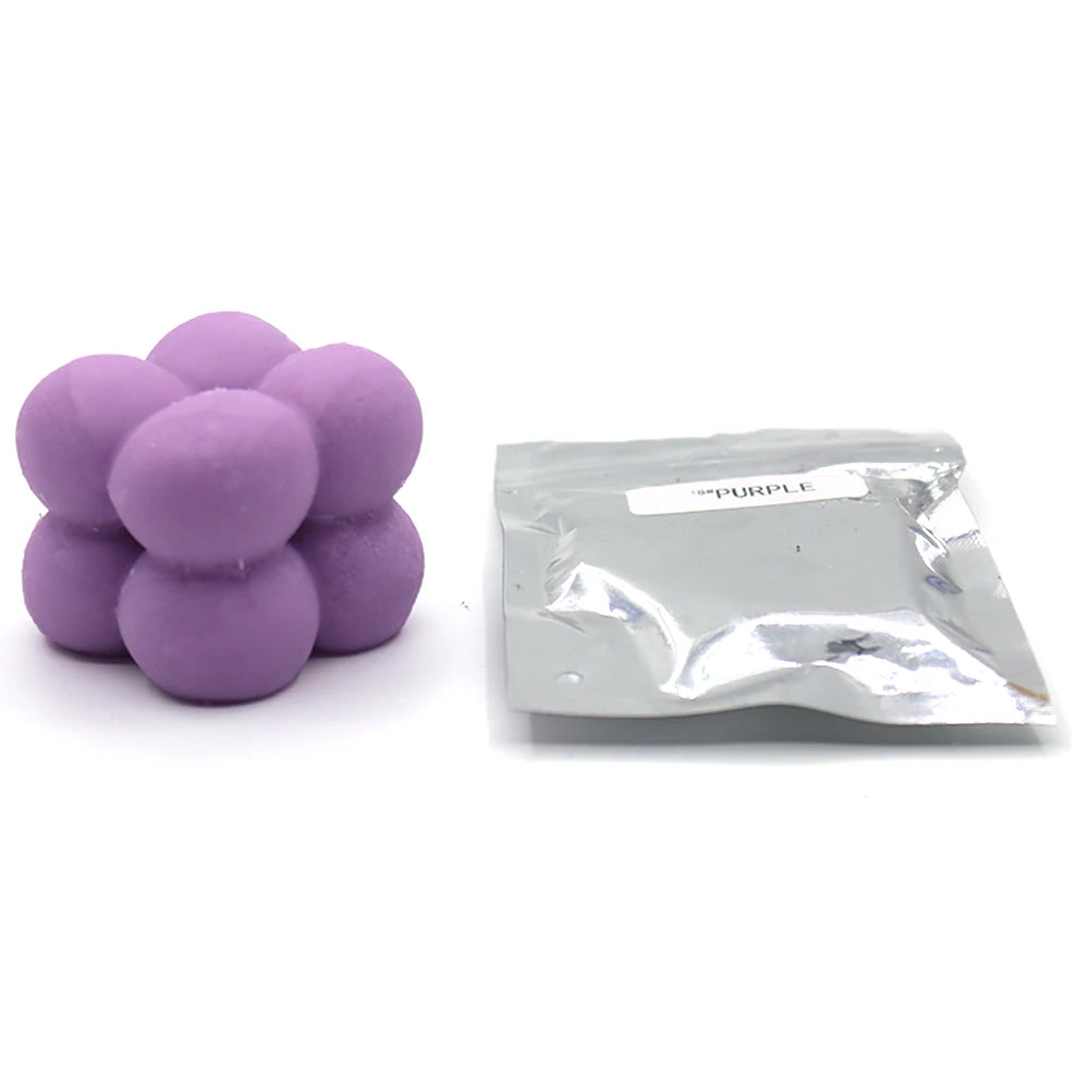 A pile of purple candle dye chips for soy wax, beeswax, and paraffin wax.