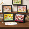 A display of various floral art paintings and a set of 3D flower building blocks for a DIY craft kit.