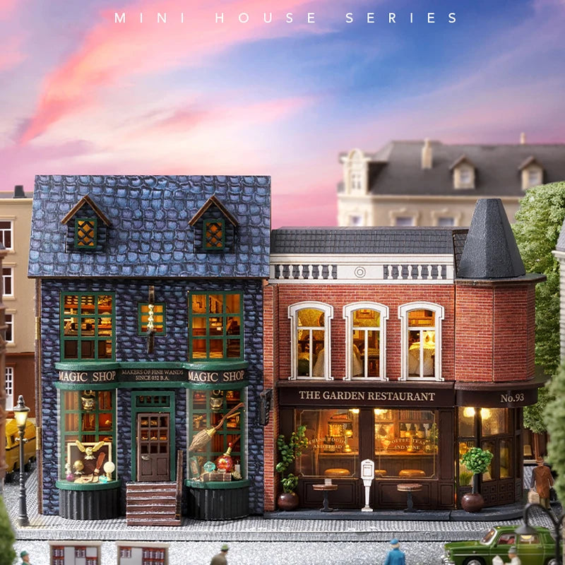A miniature wooden dollhouse kit of a pink princess villa with LED lights displayed in a street scene.