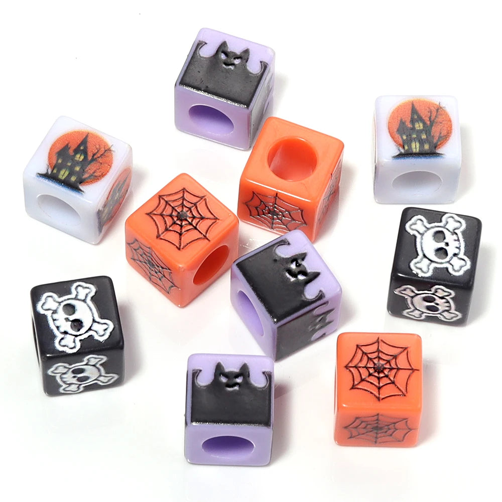 A set of Halloween themed acrylic beads in orange, purple, and black featuring spiders and skulls for DIY jewelry.