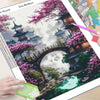 A diamond painting kit featuring a detailed scenic landscape with a pagoda, bridge, and pink cherry blossoms.