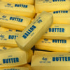 Yellow butter sticks in packaging are shown from above, with labels indicating 4oz salted butter.