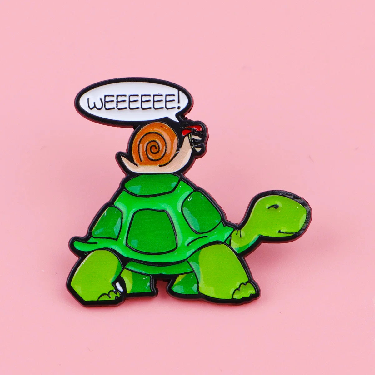 A green turtle enamel pin with a speech bubble saying Weeeeeee!
