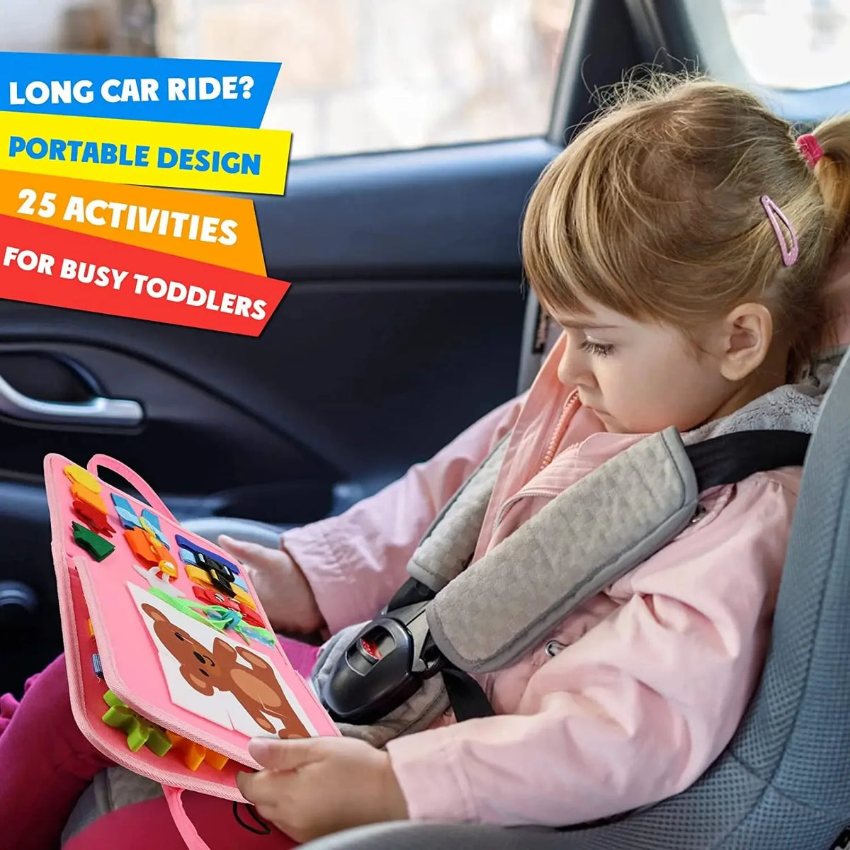 A toddler is engaging with a pink Montessori busy board activity in the car seat.