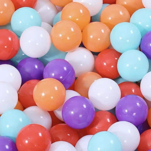 A close-up view of a large assortment of colorful plastic balls in various shades including orange, pink, purple, and light b