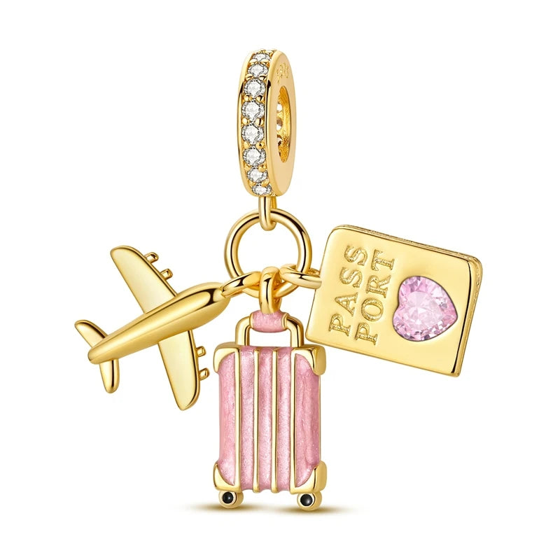 A gold-toned charm featuring a passport tag and a pink heart bead, suspended from a sterling silver chain.