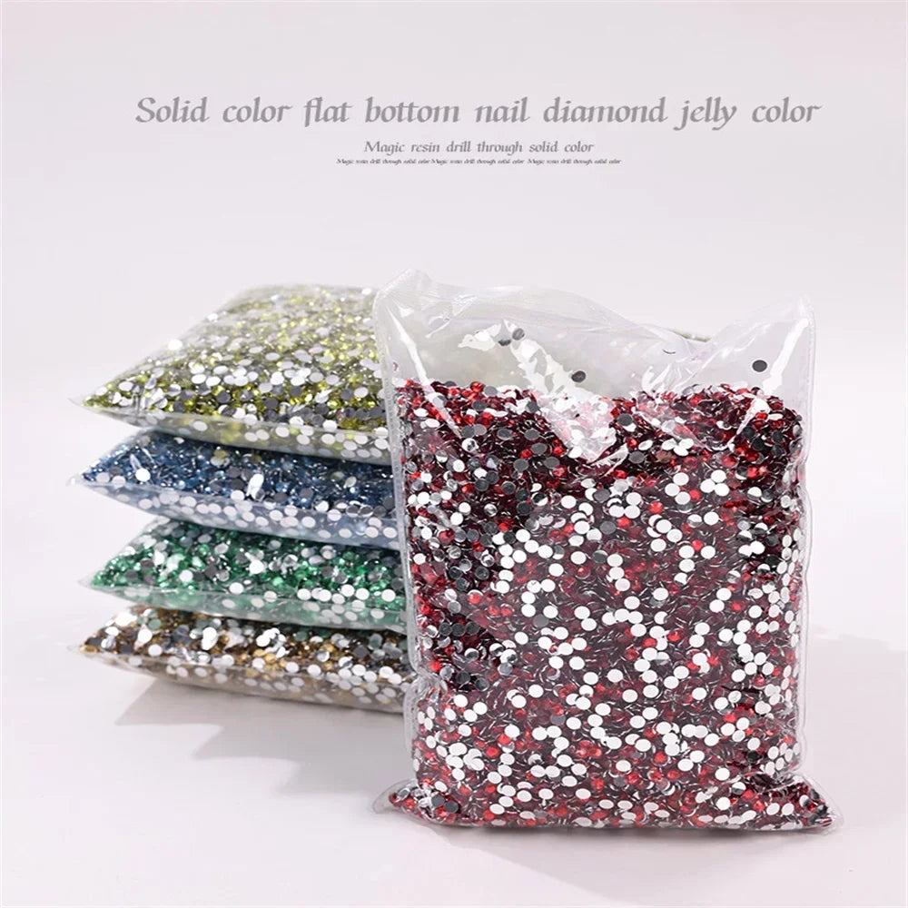 A clear plastic bag filled with solid color flat bottom nail diamond jelly colored resin rhinestones.