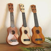 Three wooden toy guitars with ukulele sound, featuring natural wood finishes and strings.