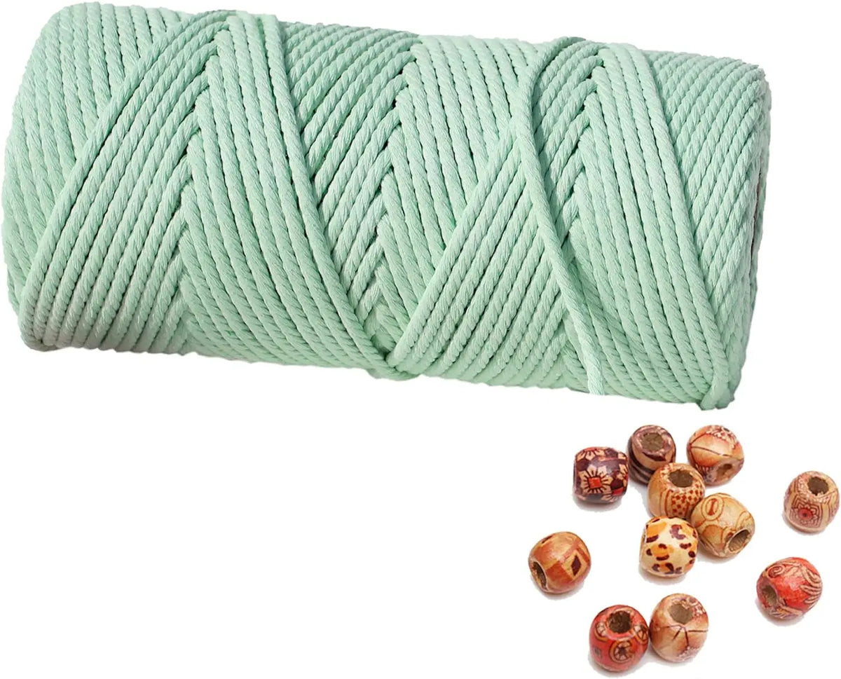 A spool of light green natural cotton macrame rope used for crafts and decor.