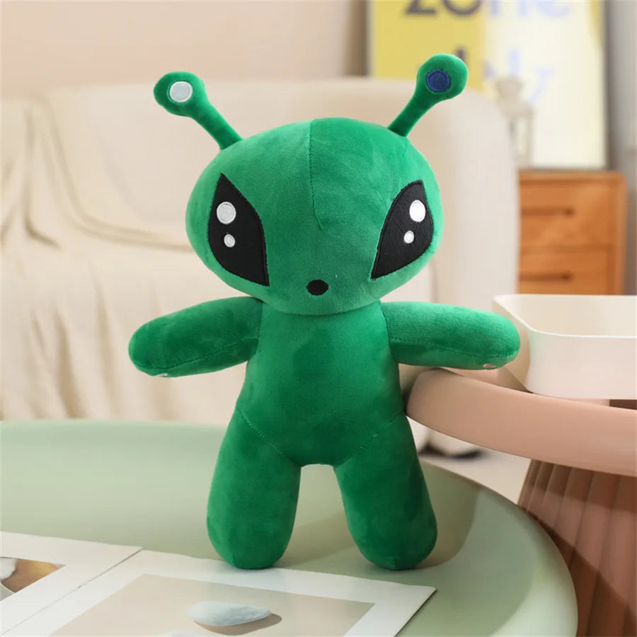 An adorable green alien plush toy with long ears sitting on a light green surface.