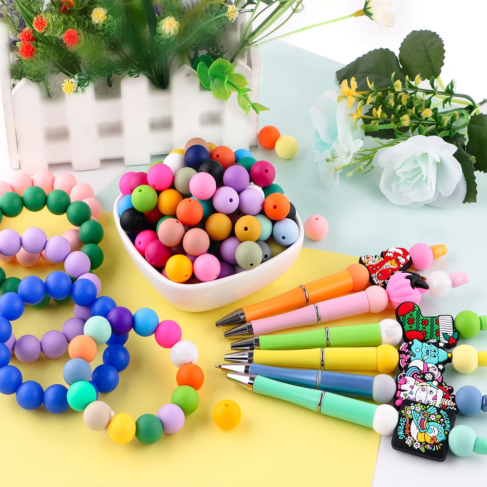 A collection of colorful soft silicone round beads in various shades are displayed on a yellow surface.