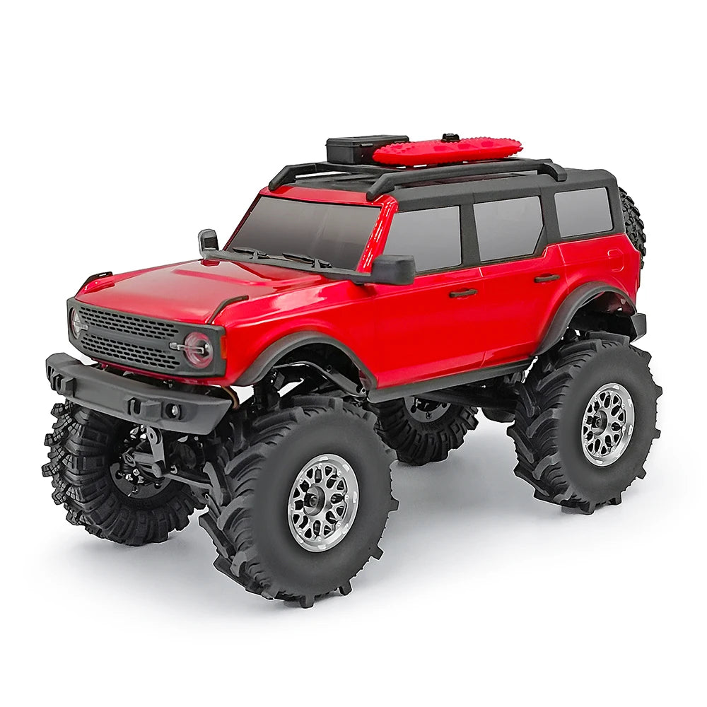 Un véhicule RC crawler rouge avec des roues en caoutchouc souple et un porte-bagages noir sur fond blanc.