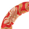 Close-up of a red fabric featuring intricate gold embroidery and decorative patterns.