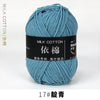 A skein of teal milk cotton yarn labeled 17# knitting and crochet thread.