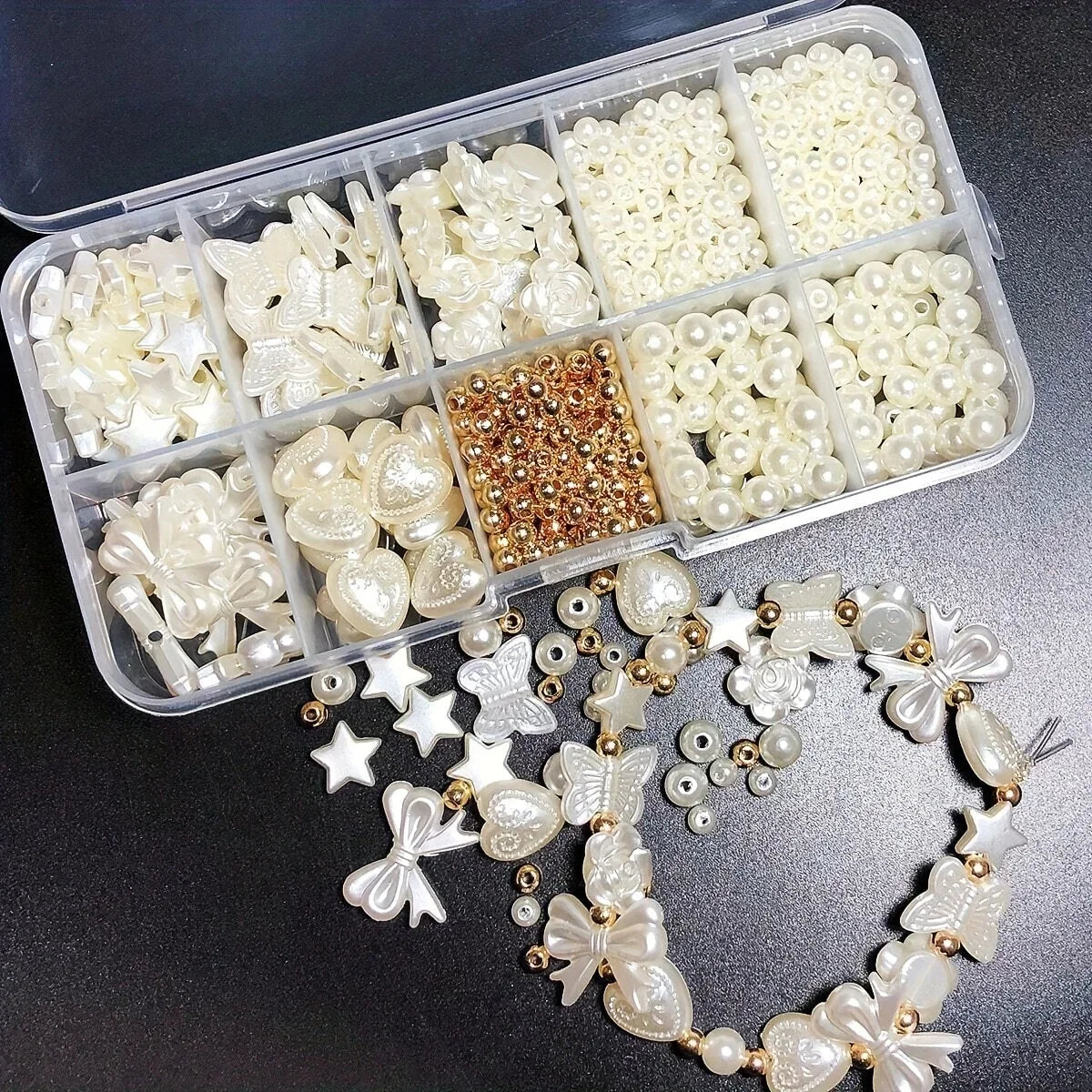 A clear plastic box holds various white acrylic pearl bead mixes for jewelry making, with loose beads displayed below.
