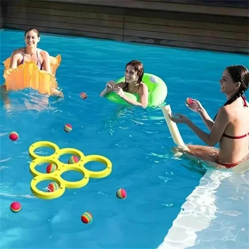A woman floats in a yellow inflatable and another woman floats in a green inflatable in a swimming pool with colorful balls.