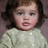 A close-up portrait of a realistic reborn baby doll named Pippa with blue eyes and brown hair wearing a light green patterned