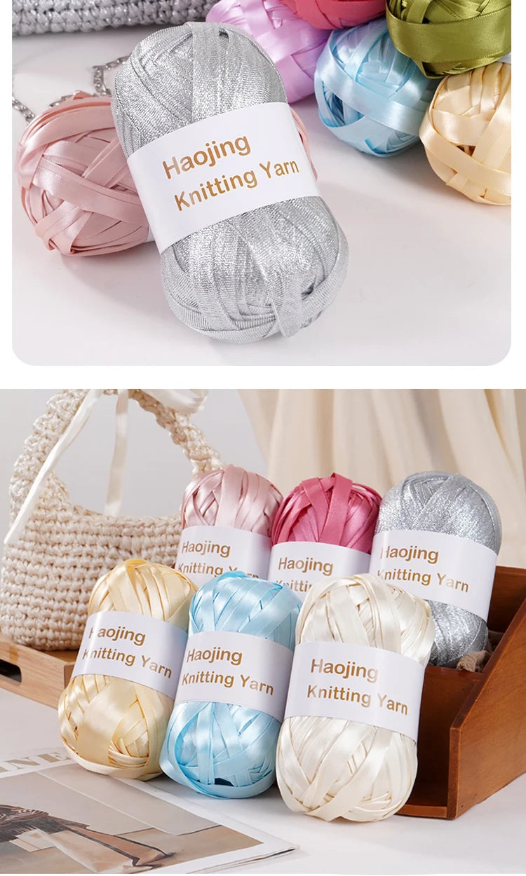 A collection of nine colored satin ribbon yarn skeins displayed in an open wooden box.