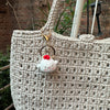 A handcrafted crochet animal keychain featuring a white rabbit or chick charm attached to a gold-toned ring.