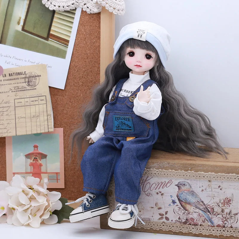 A doll wearing a denim outfit with a white collar and a light blue cap sits on a wooden box.
