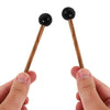 A pair of wooden handpan drum mallets with black silicone tips being held by hands.